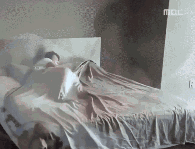 a person is laying on a bed with a mbc logo on the corner