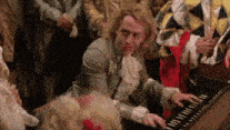 a man is playing a piano in front of a crowd of people .