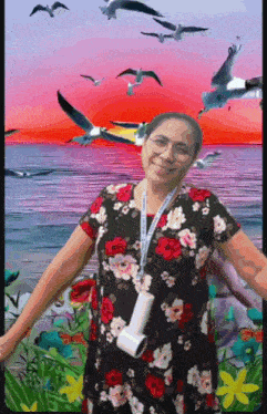 a woman in a floral dress is standing in front of a sunset