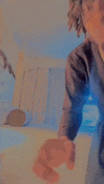 a man in a suit and sunglasses is standing in a room in front of a bed .