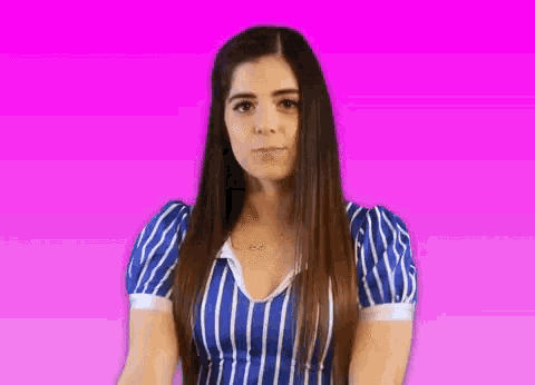 a woman wearing a blue and white striped shirt with a necklace that says infinity on it
