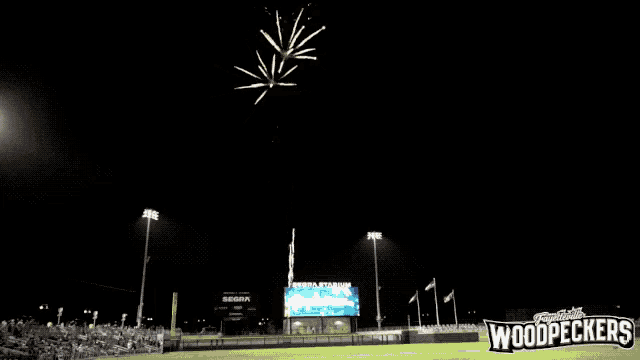 a woodpeckers baseball field at night with fireworks
