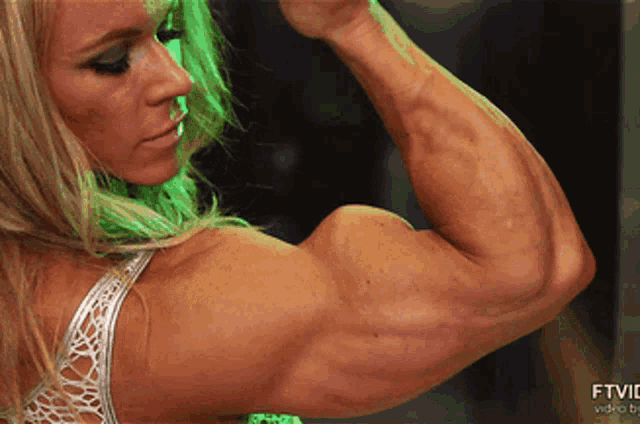 a woman flexes her muscles in front of a screen that says ftv