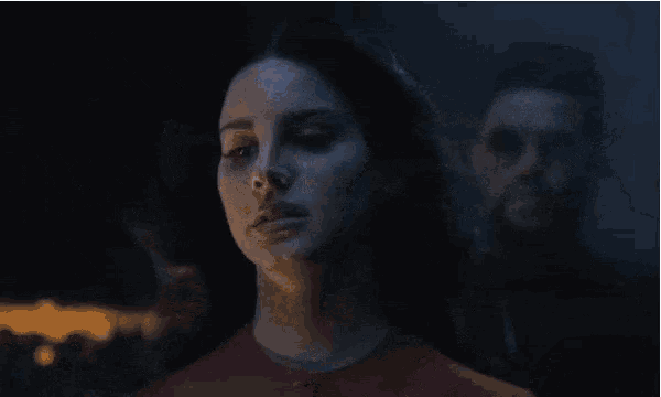 a man is holding a woman 's hand in a dark room