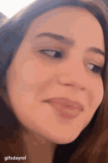a close up of a woman 's face with a nose ring on it
