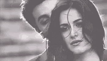 a man and a woman are standing next to each other in front of a broken window .