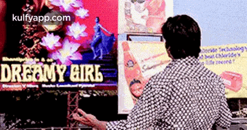 a man is looking at a screen that says dreamy girl on it .