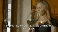a woman is drinking a glass of wine and says `` think i 'll have a little drink to chillax '' .