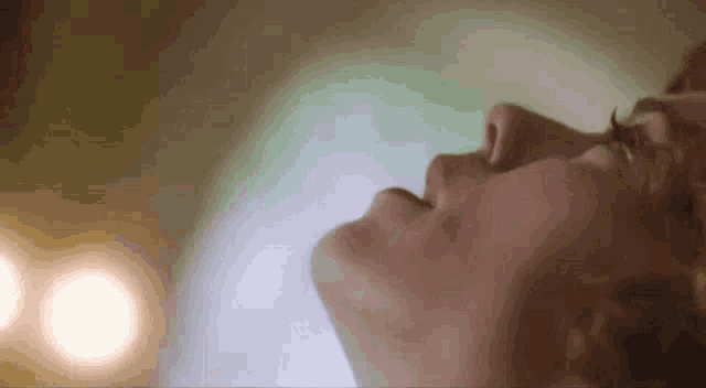 a close up of a person 's face with their eyes closed and their mouth open .