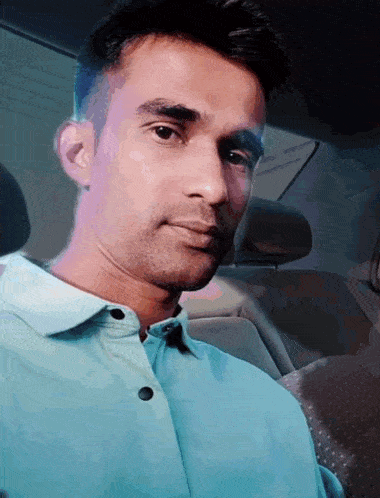 a man wearing a blue shirt is sitting in a car