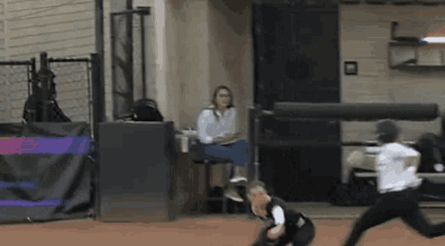 a woman sits in a chair watching a softball game