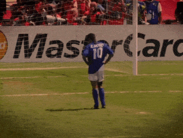 a soccer player wearing a number 10 jersey stands on the field