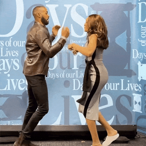 a man and a woman are dancing in front of a wall that says days of our lives