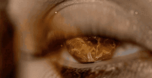 a close up of a woman 's eye with a reflection of a fireball