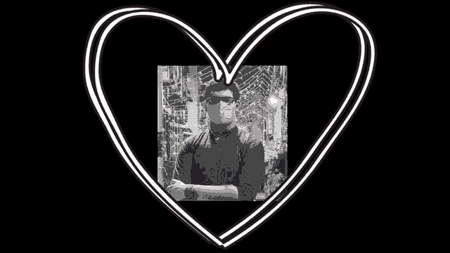 a black and white photo of a man wearing a mask and glasses in a heart shaped frame .