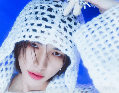 a close up of a person wearing a white crocheted hat
