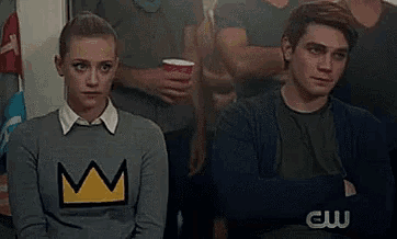 a man and a woman are sitting next to each other in a crowd .