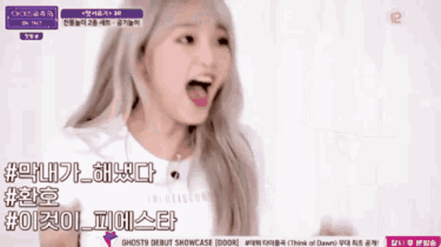 a girl with blonde hair and a white shirt is screaming in a video that says ghost9 debut showcase