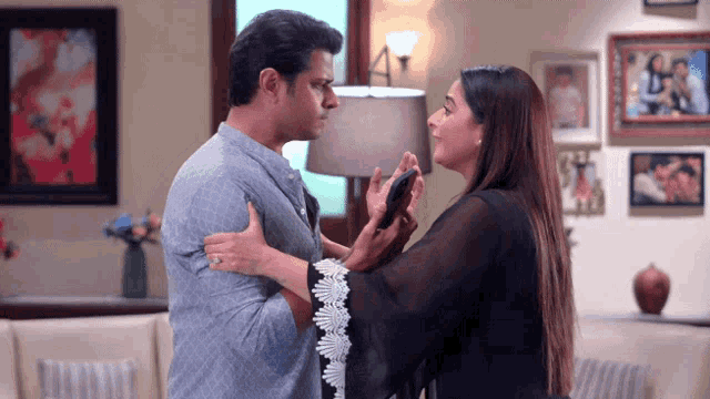 a man and a woman are standing next to each other in a room