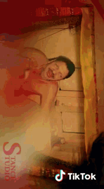 a man with a beard is laying on a bed with a tik tok watermark