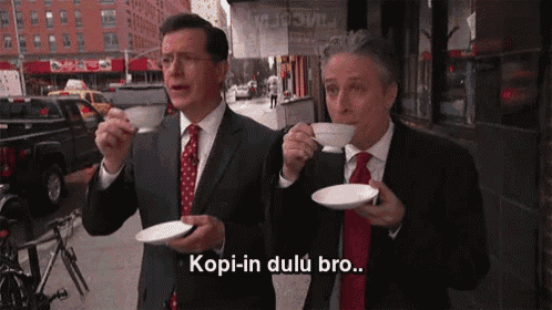 two men in suits and ties drinking coffee on a sidewalk with the caption kopi-in dulu bro