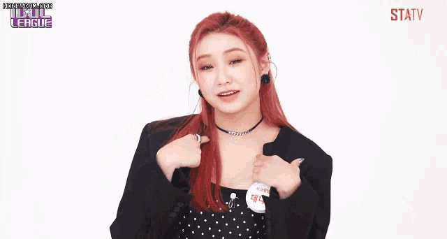 a woman with red hair is wearing a black jacket and a polka dot dress