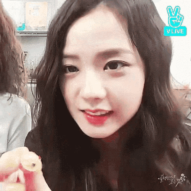 a close up of a woman 's face with a v live logo in the corner .