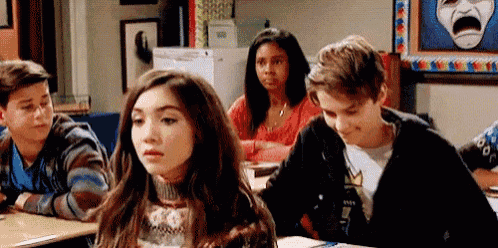 a group of students are sitting at their desks in a classroom .