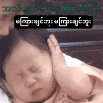 a baby is being held by a woman with foreign writing on the bottom right