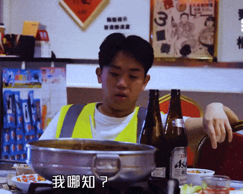 a man sitting at a table with a bottle of asahi beer in front of him