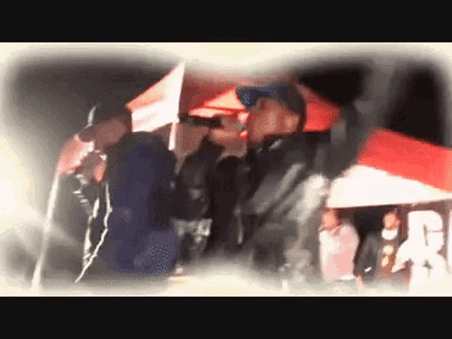 a group of people standing under umbrellas with a man holding a flag