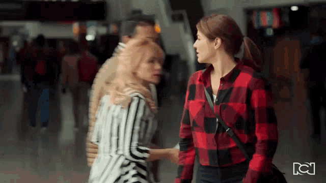 a woman in a plaid shirt is standing next to another woman