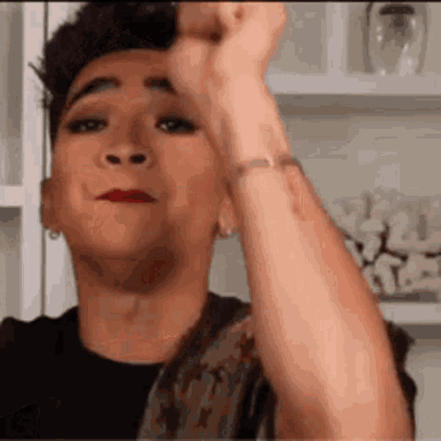 a man is making a funny face while holding his fist in the air .