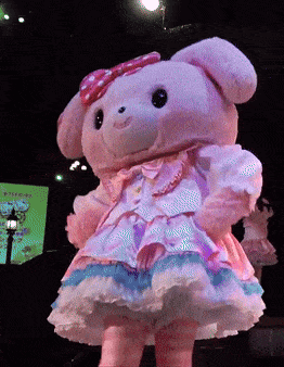 a pink teddy bear wearing a pink and white dress