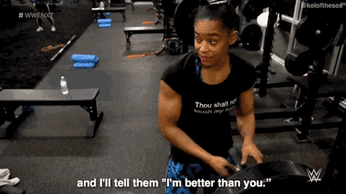 a woman in a black shirt is talking to another woman in a gym .