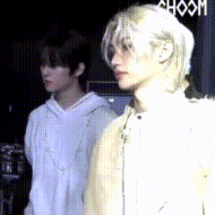 two people are standing next to each other in front of a sign that says ' hoom ' on it