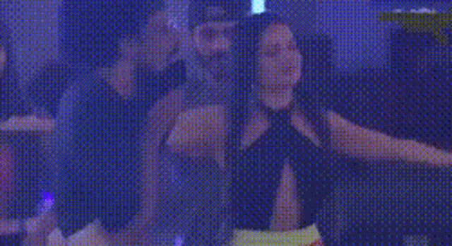 a woman in a black dress is dancing with her arms outstretched .