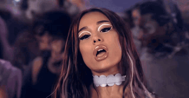 a close up of a woman wearing a choker and white eye makeup