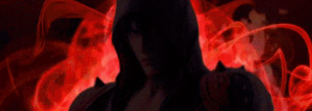 a man in a hooded jacket stands in front of a red background