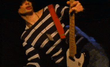 a man in a suit is playing drums in a blurry photo