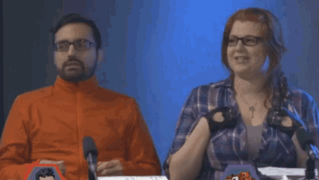 a man and a woman are sitting in front of microphones and the woman is saying damn it