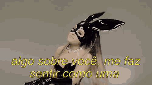 a woman wearing a black bunny mask and gloves says " algo sobre você me faz sentir como uma "