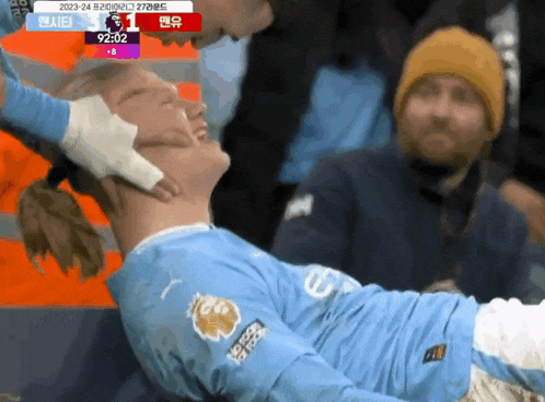 a soccer player with a bandage on his neck is laying down