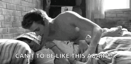 a man is kissing a woman on the forehead in a bed .