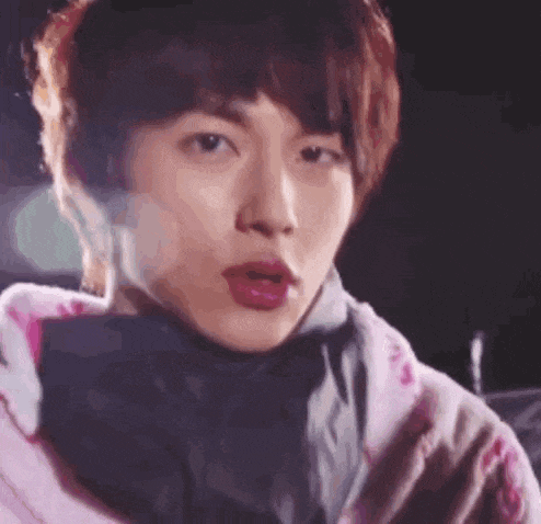 a close up of a person 's face with a pink sweater on .