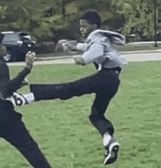 a man is kicking another man in the face while playing soccer .