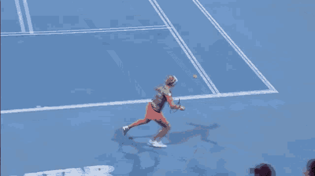 a woman is playing tennis on a court with a total sign in the background
