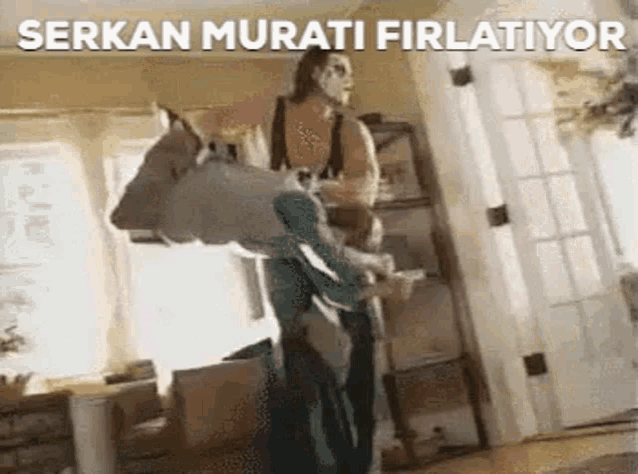 a woman is carrying a child on her back in a living room .