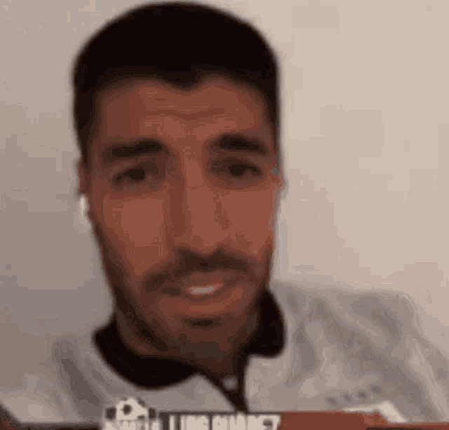 a man with a beard is wearing headphones and a white shirt