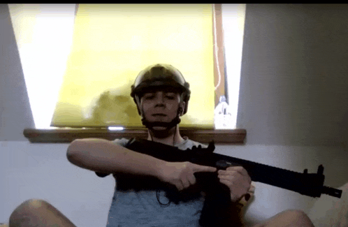 a man in a helmet is holding a gun